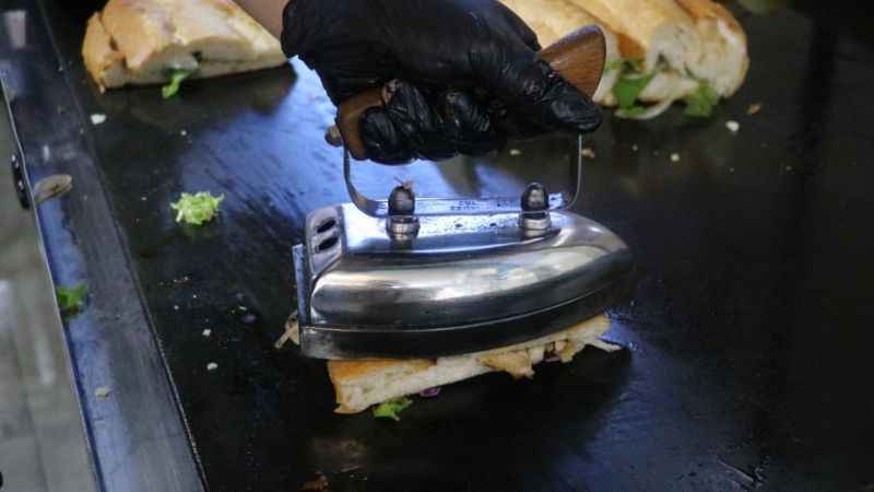 Ütü ile ekmek arası balıkları tost yapıp satıyor