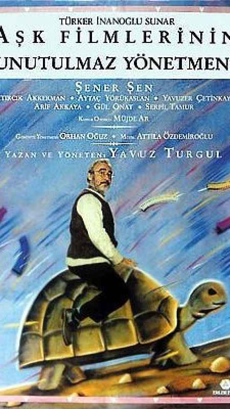 1990 yapımı Aşk Filmlerinin Unutulmaz Yönetmeni filminin afişinde filmin başrol oyuncusu Şener Şen hangisinin üzerine binmiş şekilde tasvir edilir?