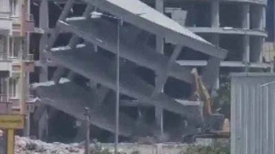 Yıkım esnasında bina iş makinesinin üzerine devrildi